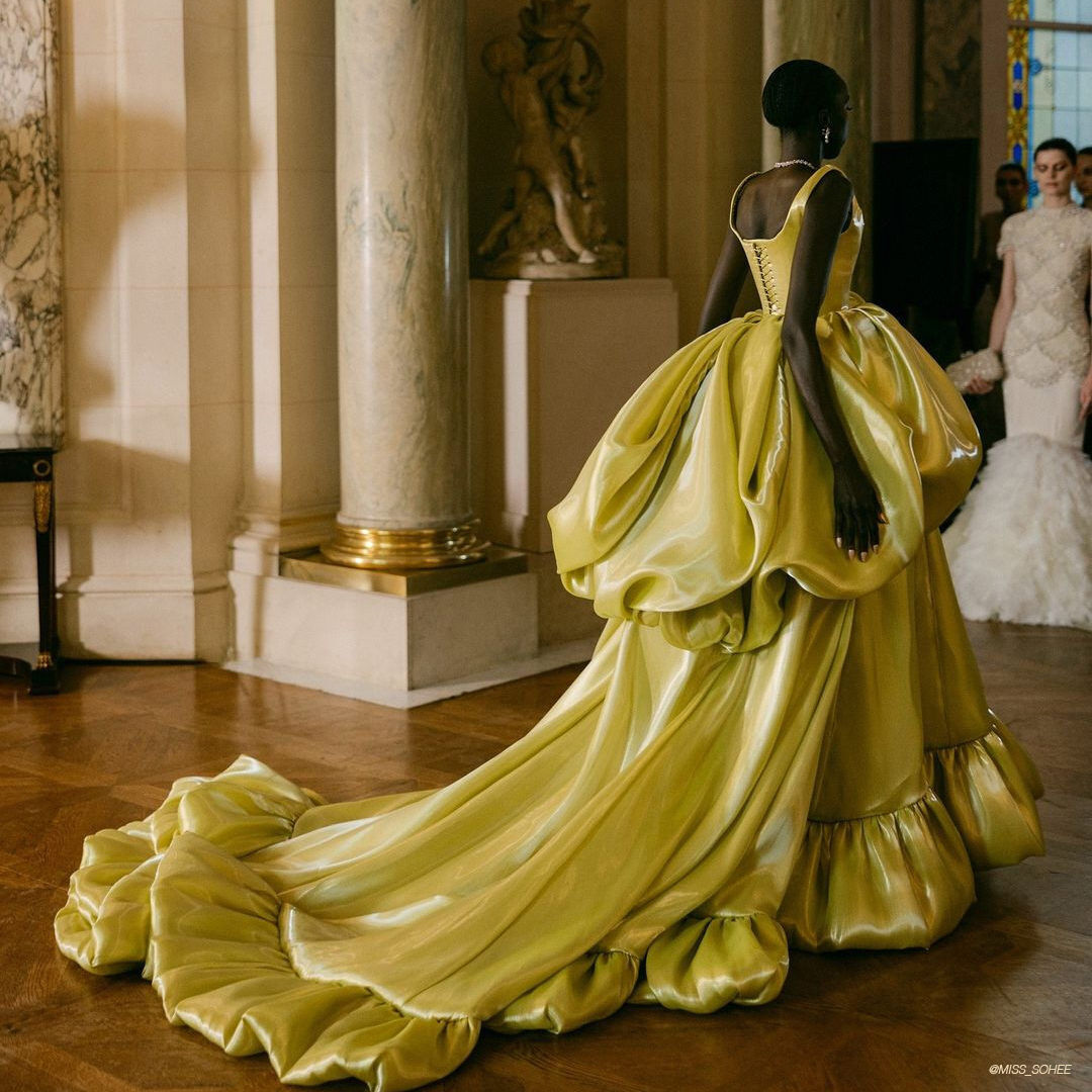 Model in yellow gown embodying fashion week elegance.